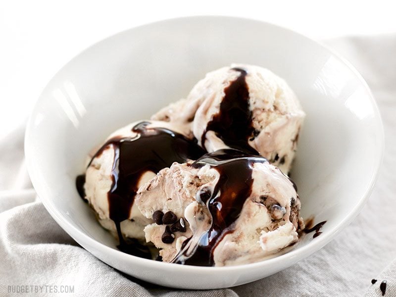 Silky smooth and creamy No-Churn Mint Chocolate Chip Ice Cream is easy to make at home with just a few ingredients and very little effort. BudgetBytes.com A bowl of No-Churn Mint Chocolate Chip Ice Cream with chocolate syrup on top
