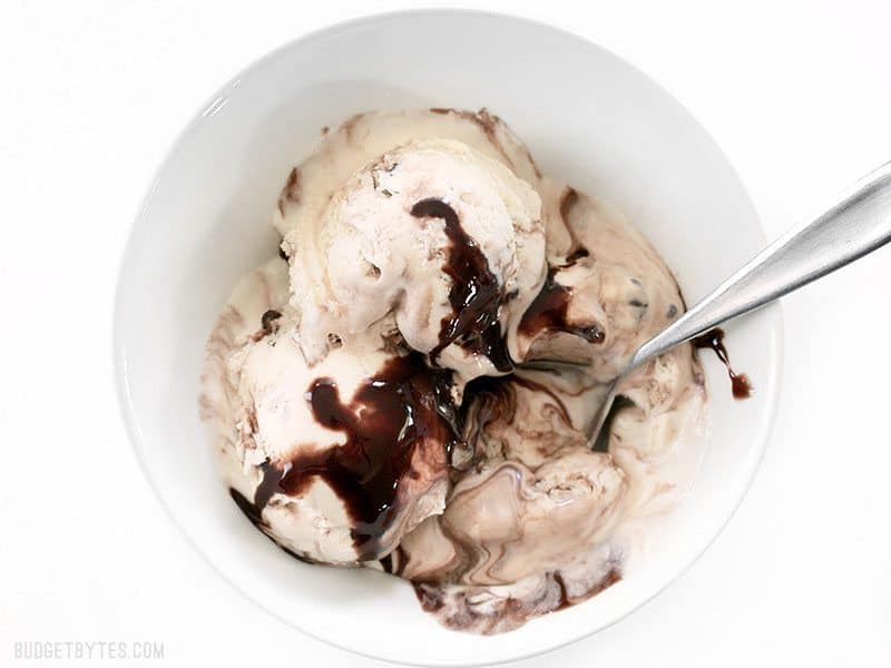 Silky smooth and creamy No-Churn Mint Chocolate Chip Ice Cream is easy to make at home with just a few ingredients and very little effort. BudgetBytes.com Overhead view of a half-melted bowl of No-Churn Mint Chocolate Chip Ice Cream