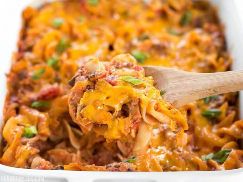 Beef & Mushroom Country Casserole is a filling and flavorful hot meal that the whole family will love, and with NO cream of soups! BudgetBytes.com Close up of Beef & Mushroom Country Casserole being scooped out of the casserole dish with a wooden spoon.