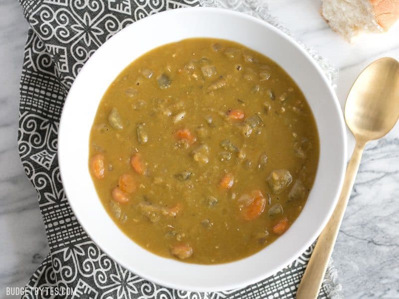 The pressure cooker gives this homemade split pea soup that all-day simmered flavor in a fraction of the time. Delicious, filling, inexpensive, and FAST! BudgetBytes.com A bowl of Pressure Cooker Split Pea Soup seen from above, on a patterned napkin.