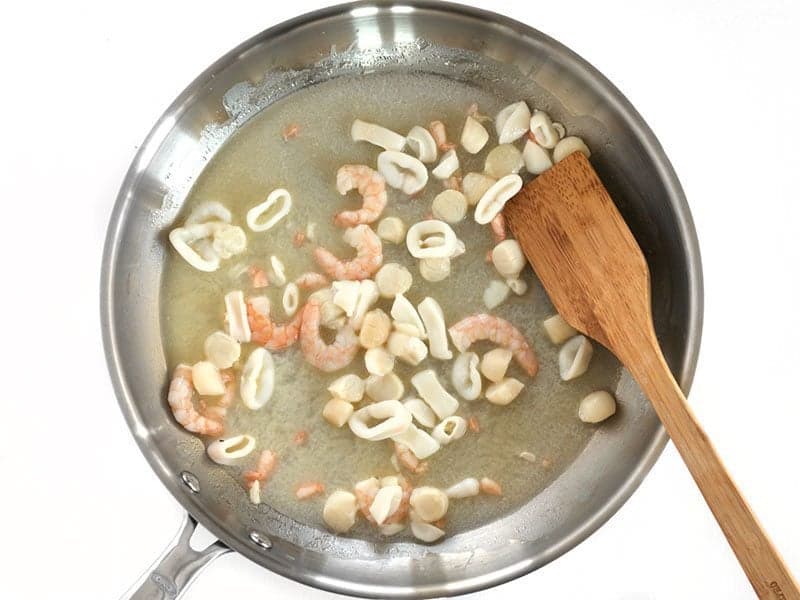 Seafood Mix being cooked with butter in the skillet.