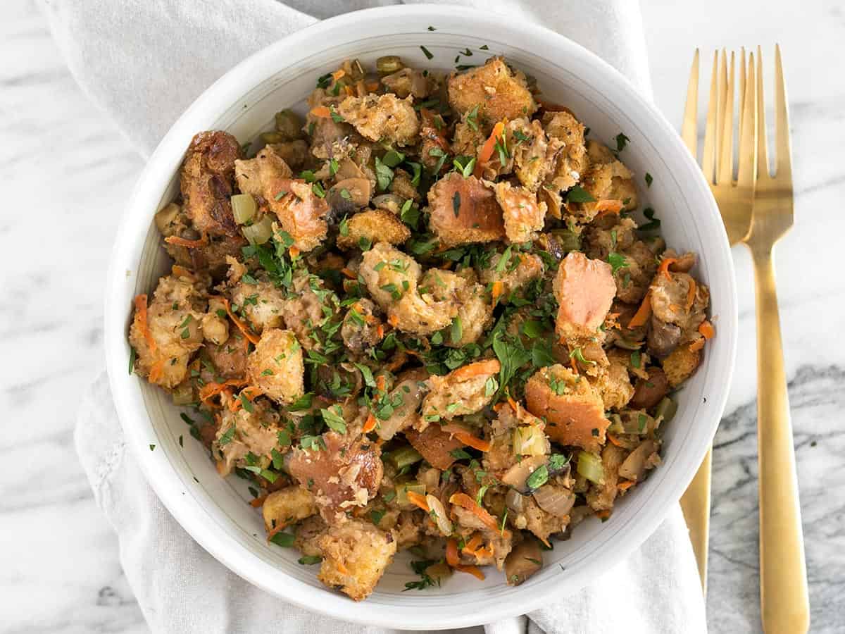 This Savory Vegetable Stuffing is full of so much color, texture, and flavor that it will be loved by meat-eaters and vegetarians alike. BudgetBytes.com Overhead view of a bowl full of vegetarian stuffing with a fork on the side.