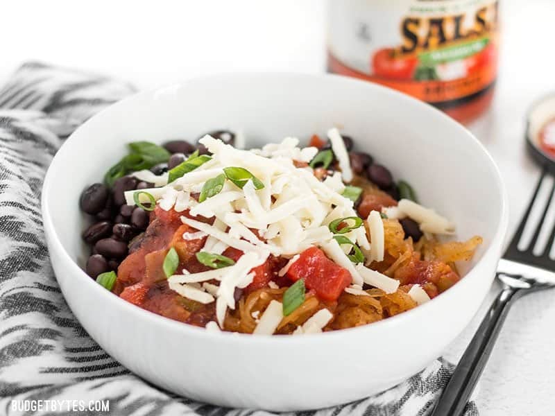 Spaghetti squash makes a great fiber-filled low-carb substitute for rice in these Southwest Spaghetti Squash Bowls. BudgetBytes.com Finished southwest spaghetti squash bowl viewed from the front, a jar of salsa in the background