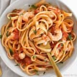 Spicy seafood fettuccine twirled with a fork.