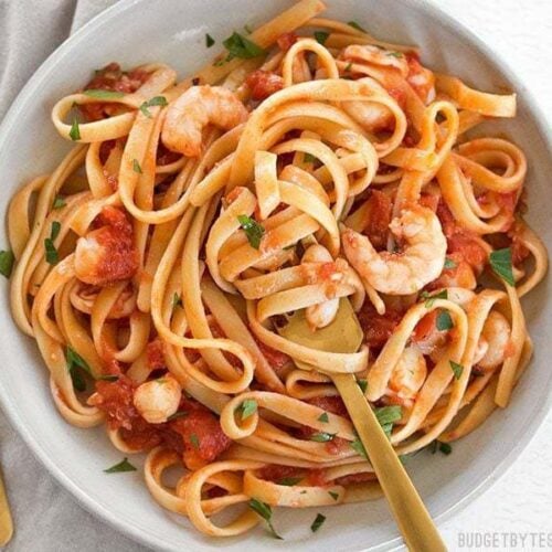 Spicy seafood fettuccine twirled with a fork.