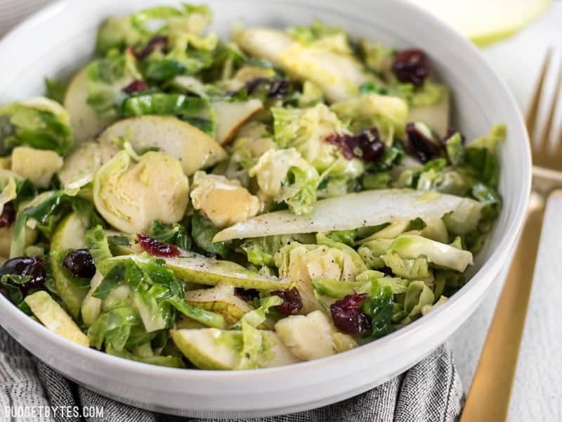 This Warm Brussels Sprouts and Pear Salad combines winter flavors in a warm and filling side dish. BudgetBytes.com Close up of Warm Brussels Sprouts and Pear Salad in the bowl, from the front
