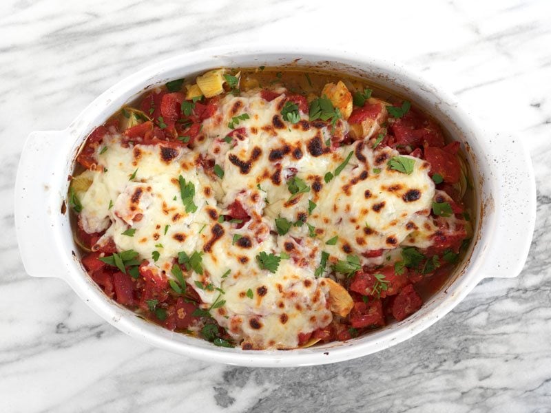 Baked Chicken with Artichokes and Tomatoes is an easy and flavorful weeknight dinner you can make with pantry staples. Budgetbytes.com Finished Baked Chicken with Artichoke Hearts, garnished with parsley