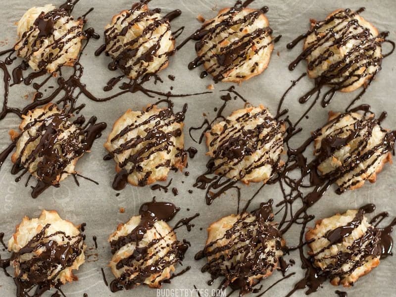 These Chocolate Glazed Macaroons feature a combination of vanilla, almond, and fresh orange zest for an extra fragrant and flavorful cookie. Budgetbytes.com Finished Chocolate Glazed Macaroons on a parchment lined baking sheet, viewed from above