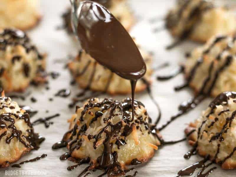 These Chocolate Glazed Macaroons feature a combination of vanilla, almond, and fresh orange zest for an extra fragrant and flavorful cookie. Budgetbytes.com Close up shot of Chocolate being drizzled over a Chocolate Glazed Macaroon.