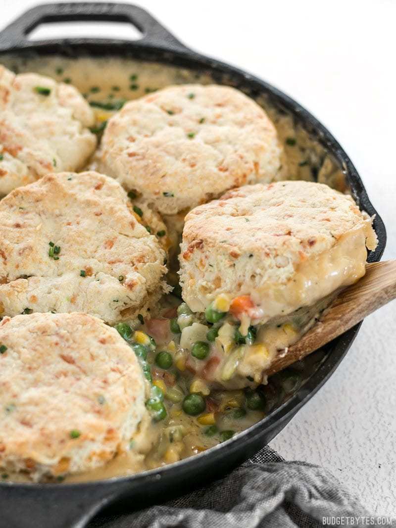 This rich and comforting Vegetable Pot Pie Skillet is made fast and easy for weeknight dinners thanks to frozen vegetables. Comfort food all in one skillet! Budgetbytes.com Side shot of the Vegetable Pot Pie Skillet with a scoop of Cheddar Biscuit Topping