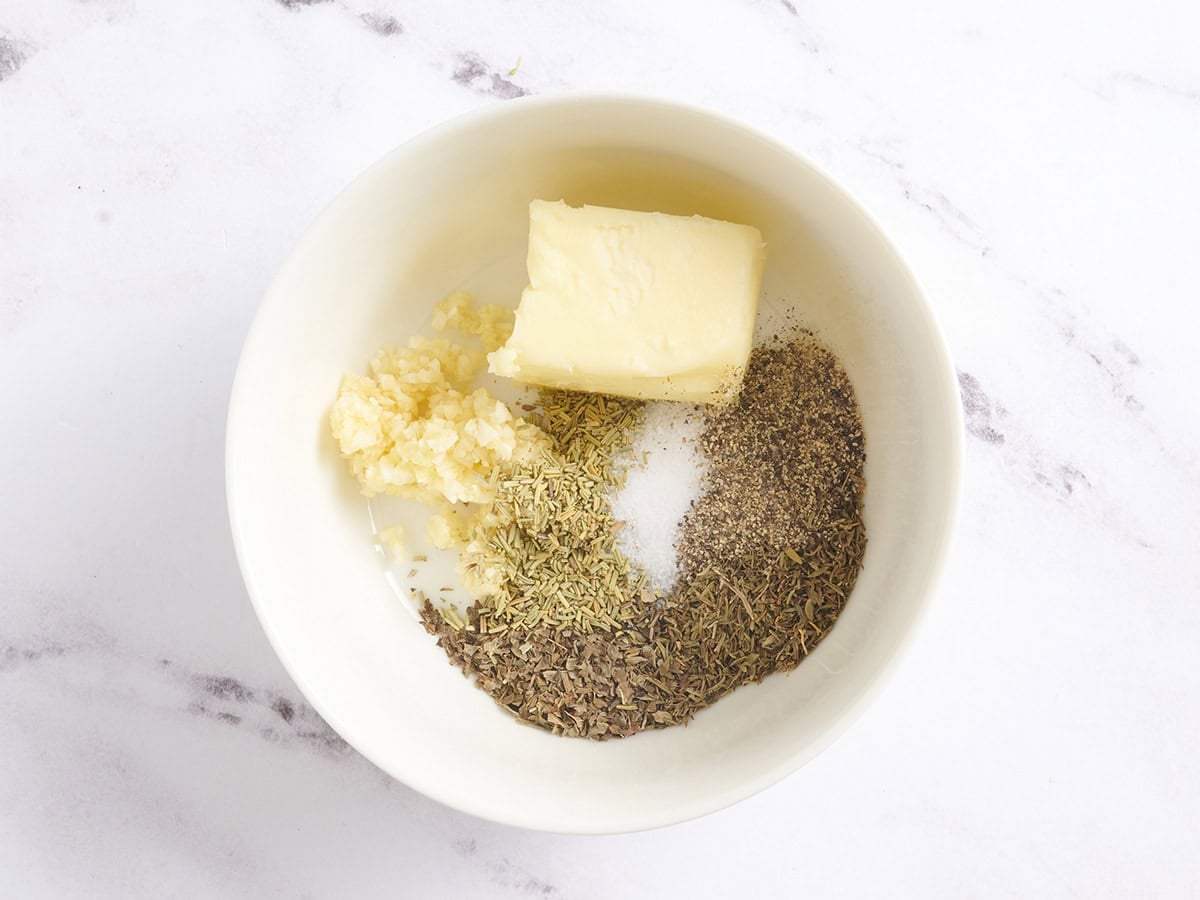 Herbs, butter and salt in a bowl.