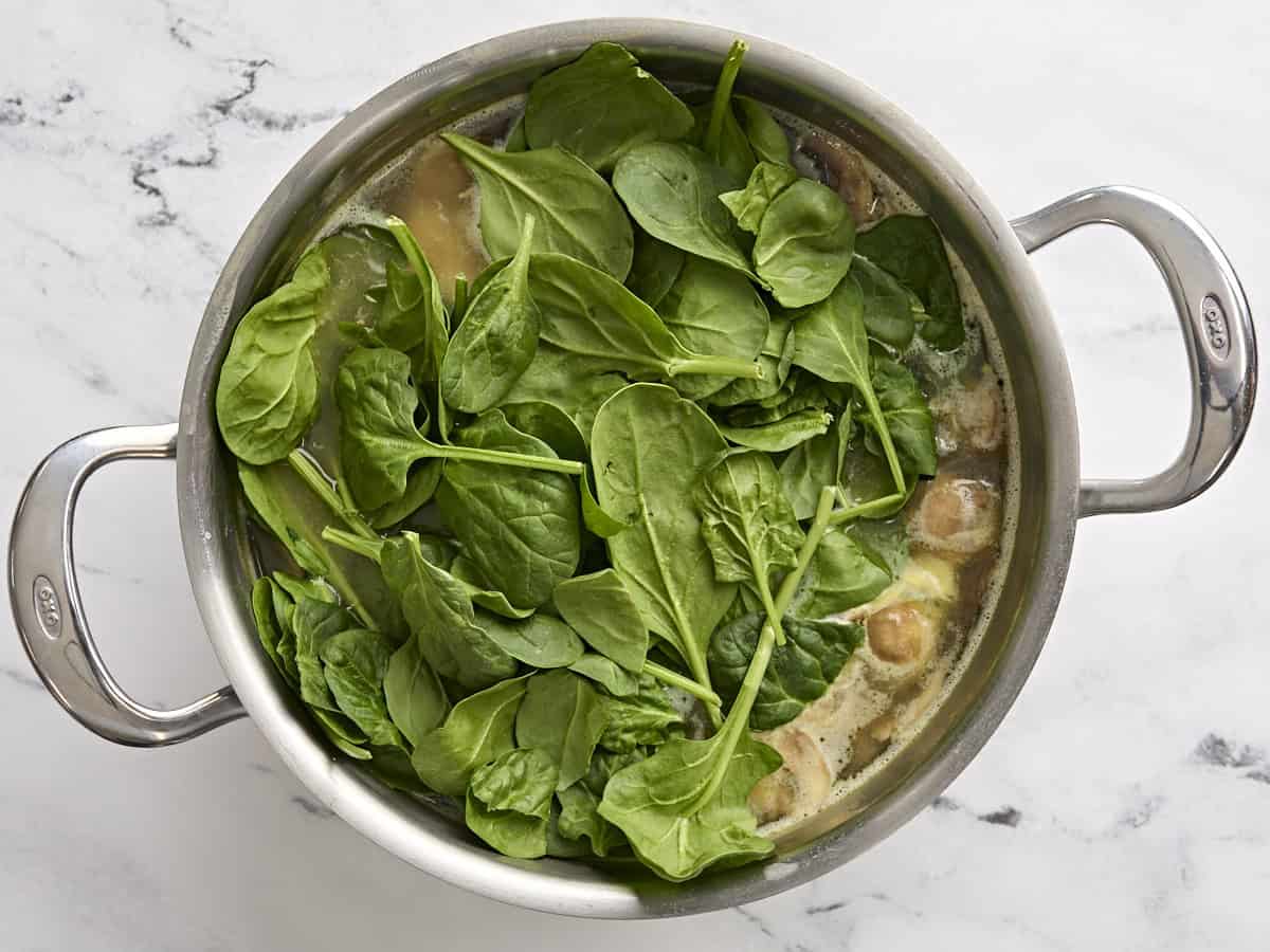 Spinach added to a pot of egg drop soup.