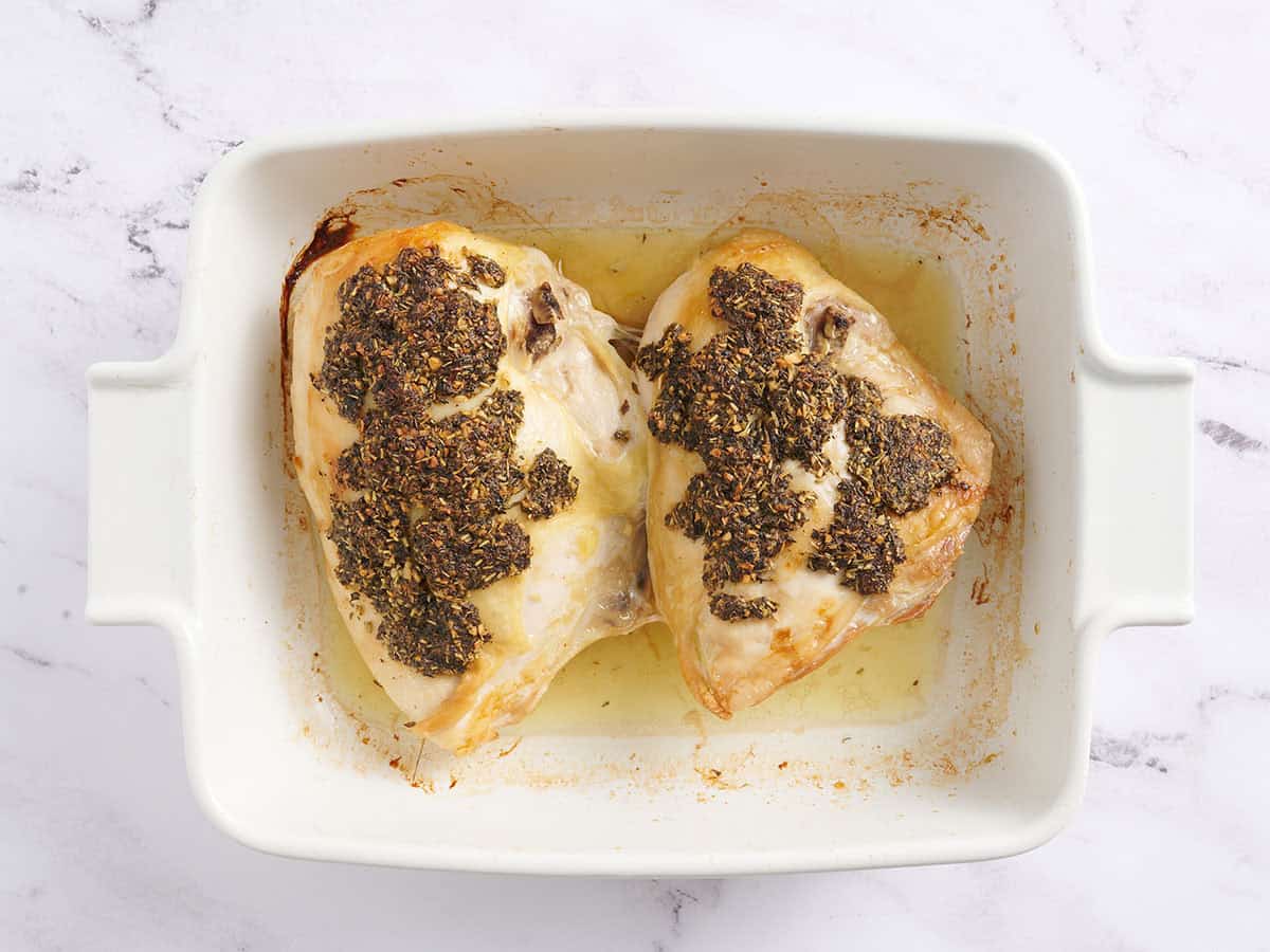 Herb roasted chicken breasts in a baking dish.