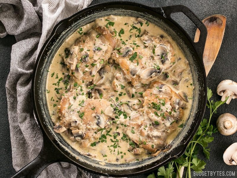 Simple pan sauces save the day in this quick and easy Creamy Garlic Mushroom Chicken! BudgetBytes.com Finished Creamy Garlic Mushroom Chicken in the skillet, garnished with chopped parsley