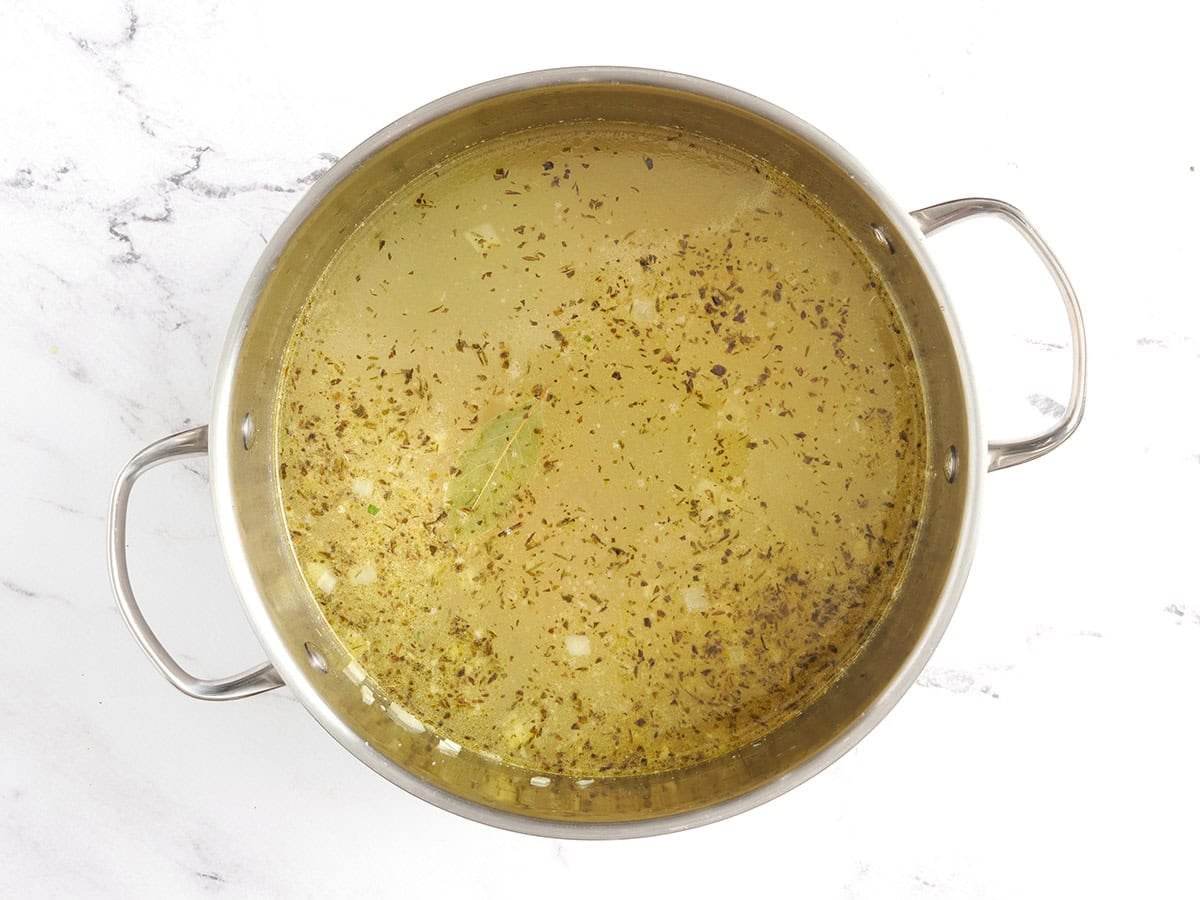 Chicken noodle soup base before simmering in a soup pot.