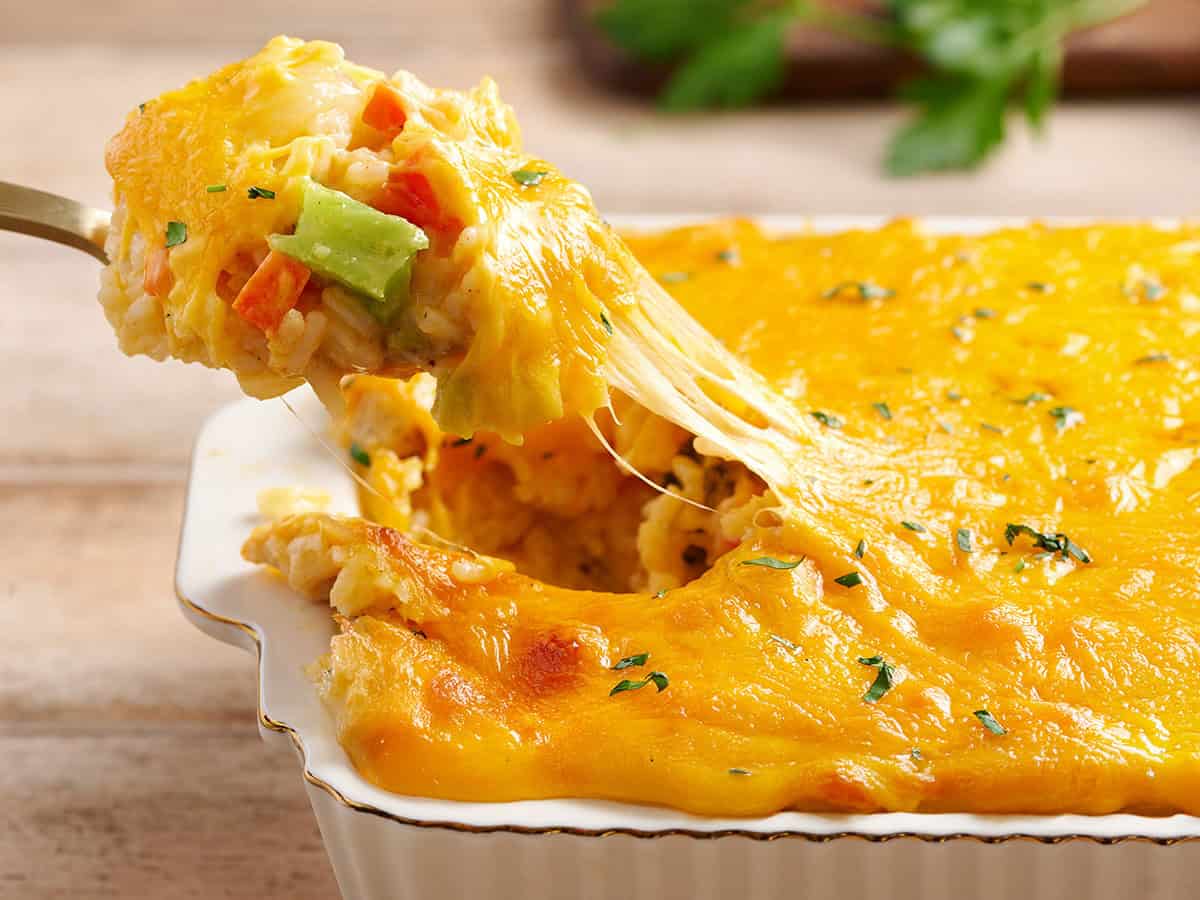 Side view of cheese pull from a chicken and rice casserole