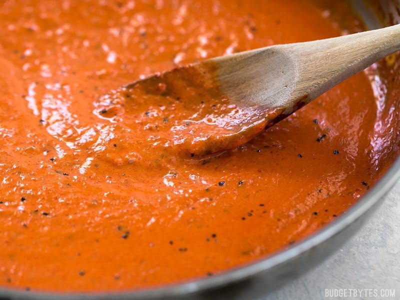 Creamy Roasted Red Pepper Sauce is a great alternative to tomato based sauces for pasta, pizzas, or just for dipping your favorite crusty bread. BudgetBytes.com Close up of Creamy Roasted Red Pepper Sauce in the skillet from the side