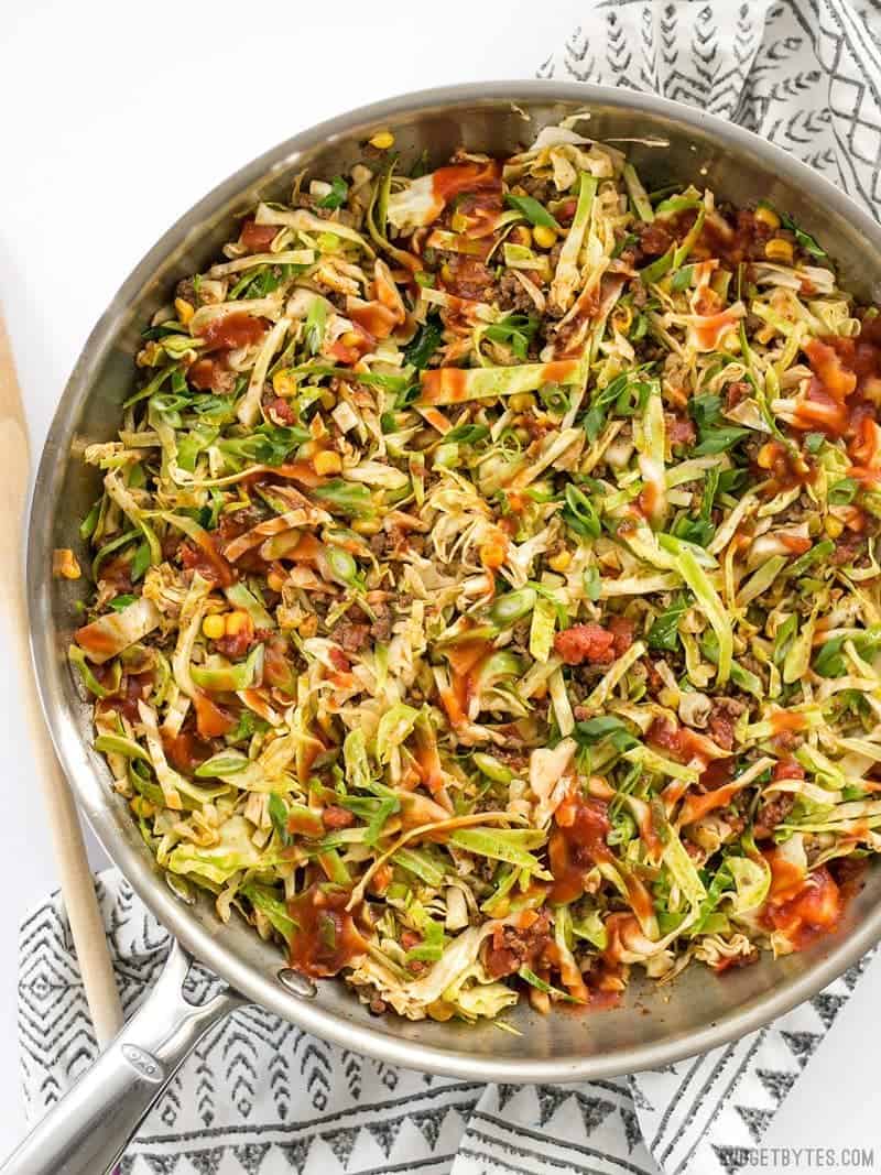 This Southwest Beef and Cabbage Stir Fry is a fast, easy, and flavorful way to make sure dinner is filled with plenty of vegetables. BudgetBytes.com A skillet full of Southwest Beef and Cabbage Stir Fry with taco sauce drizzled over top