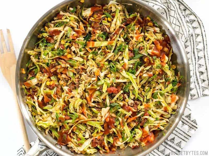 This Southwest Beef and Cabbage Stir Fry is a fast, easy, and flavorful way to make sure dinner is filled with plenty of vegetables. BudgetBytes.com Close up of Southwest Beef and Cabbage Stir Fry in the skillet with wooden fork on the side