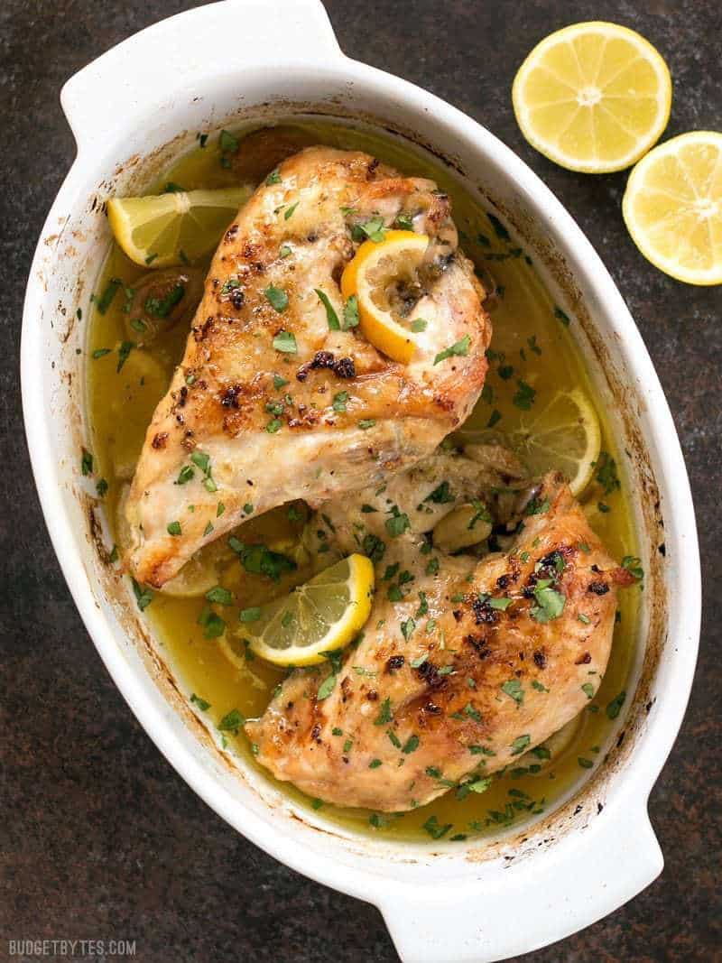 This low and slow cooking method makes this Lemon Garlic Roasted Chicken incredibly tender, juicy, and flavorful! BudgetBytes.com Finished Lemon Garlic Roasted Chicken garnished with fresh lemon slices and parsley