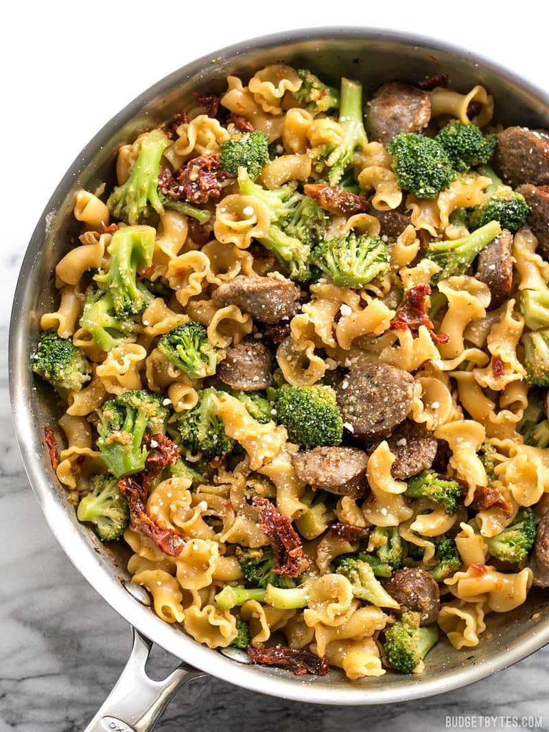This One Pot Sausage and Sun Dried Tomato Pasta cooks quickly and in one skillet so that no flavor is lost! Make dinner fast, easy, and delicious. BudgetBytes.com Close up of One Pot Sausage and Sun Dried Tomato Pasta in the skillet