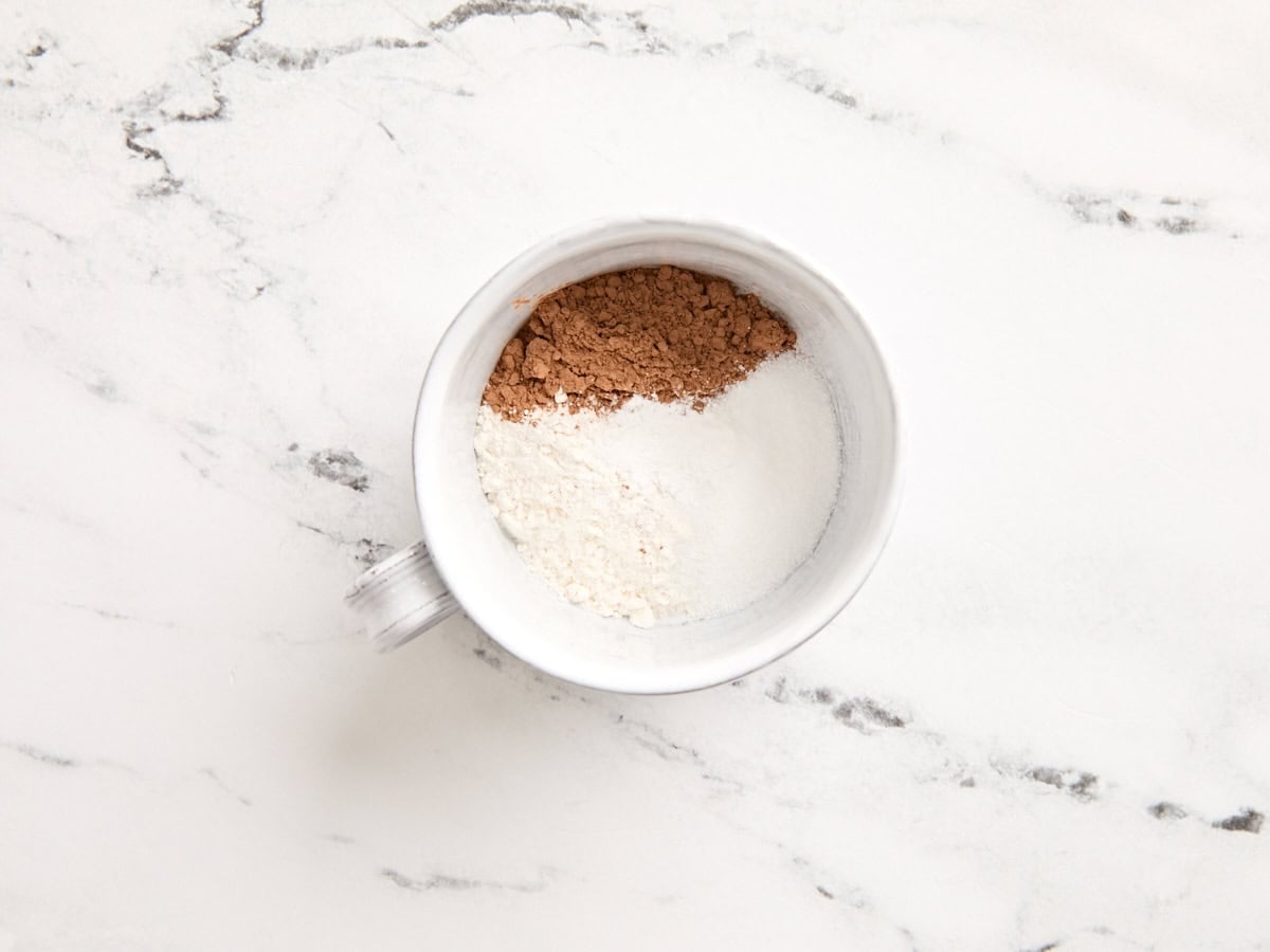 Flour, cocoa powder, and baking powder in a mug.