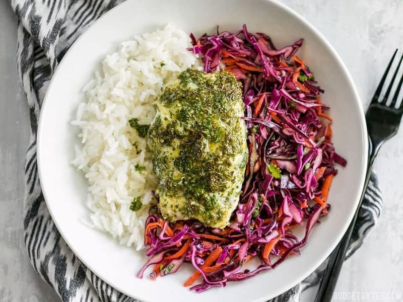 These light and fresh Baked Chimichurri Fish Bowls are simple to prepare and make great cold lunches for the rest of the week. BudgetBytes.com Finished Baked Chimichurri Fish on top of cooked rice and red cabbage slaw