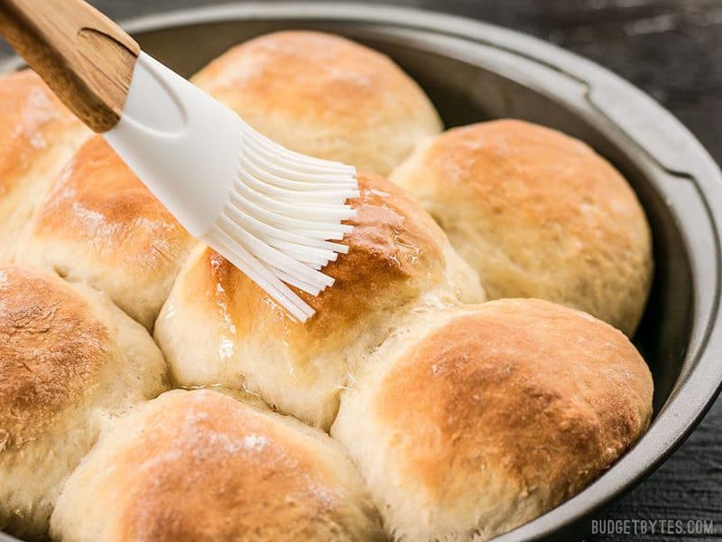 These incredible light and delicate Buttermilk Pull-Apart Rolls couldn't be easier thanks to a simple no-knead dough. BudgetBytes.com Melted butter being brushed onto the Buttermilk Pull-Apart Rolls with a silicone brush