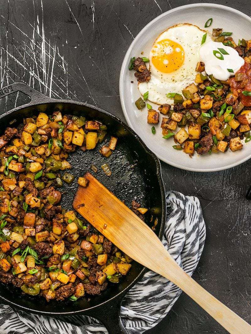 This simple but tasty Chorizo Breakfast Hash is a breakfast classic. Perfect for your lazy weekend brunch, or even "breakfast for dinner". BudgetBytes.com A cast iron skillet full of Chorizo Breakfast Hash next to a serving plate with a sunny side up egg