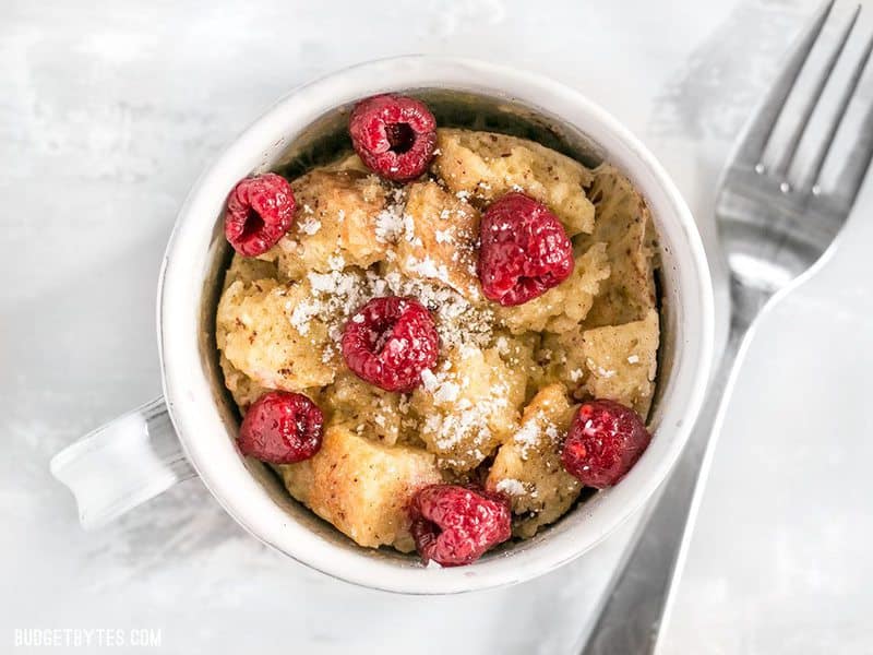 These fast and easy 5-Minute French Toast Mugs are a great single serving breakfast treat plus a way to use leftovers and reduce food waste. BudgetBytes.com Overhead close up shot of microwave french toast mug with raspberries
