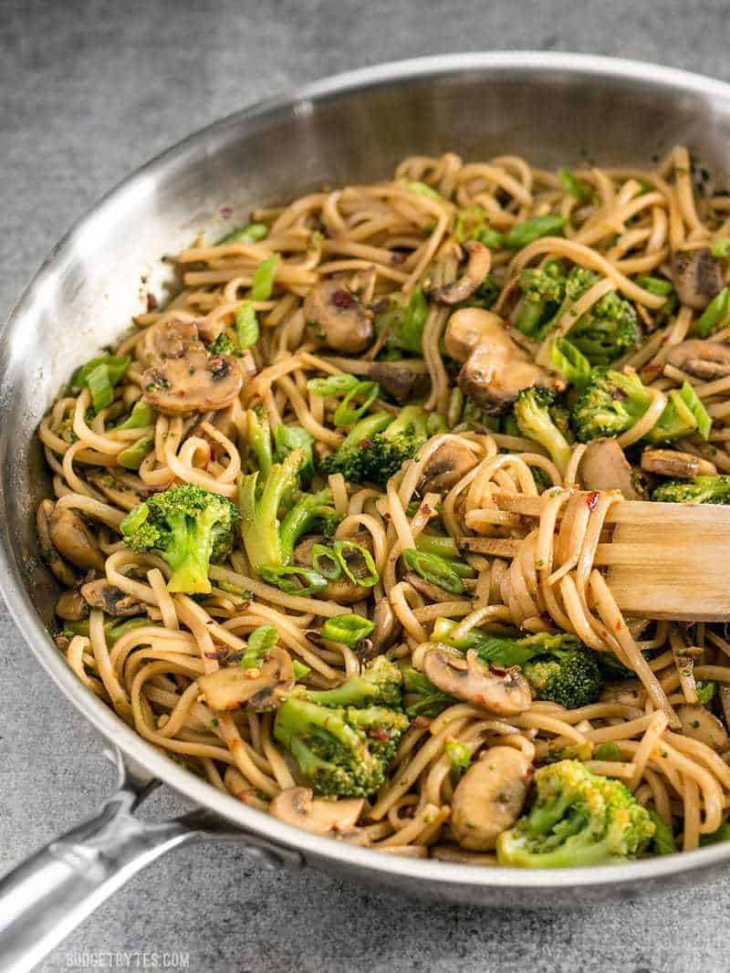 With just a few ingredients you can make these easy and delicious Mushroom Broccoli Stir Fry Noodles for a fast weeknight dinner. BudgetBytes.com Side view of the skillet full of Mushroom Broccoli Stir Fry Noodles with a wooden pasta fork