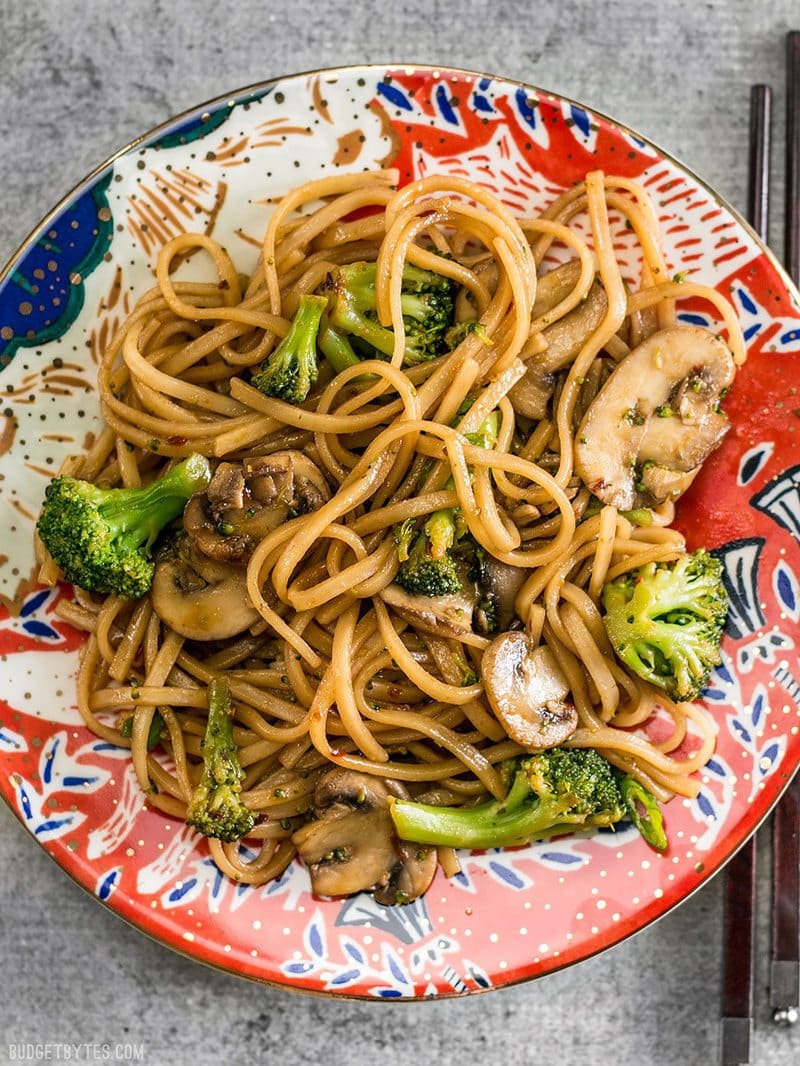 With just a few ingredients you can make these easy and delicious Mushroom Broccoli Stir Fry Noodles for a fast weeknight dinner. BudgetBytes.com A colorfully patterned plate with Mushroom Broccoli Stir Fry Noodles, chopsticks on the side
