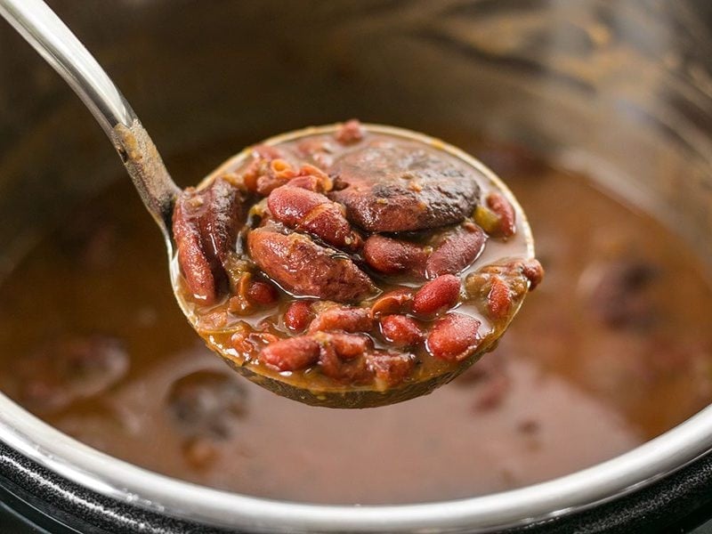 Pressure Cooker Red Beans are a fast, inexpensive, filling, and flavorful staple meal. It's a Louisiana tradition, but FASTER! BudgetBytes.com A ladle lifting a scoop of Pressure Cooker Red Beans out of the Instant Pot