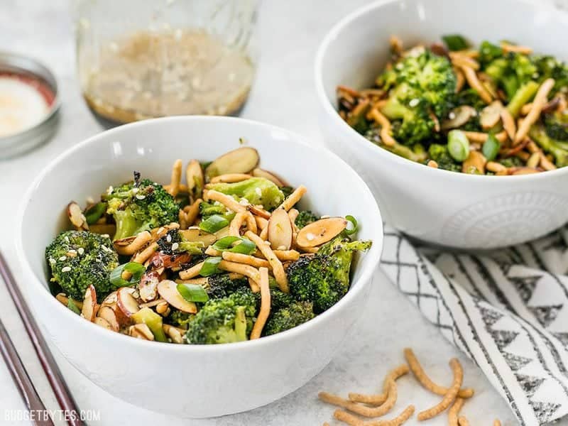 This crunchy, sweet, and salty Roasted Broccoli Salad with Almonds is my favorite way to get my vegetables and goes great with any Asian inspired meal. Budgetbytes.com Side view of two bowls of Roasted Broccoli Salad with Almonds