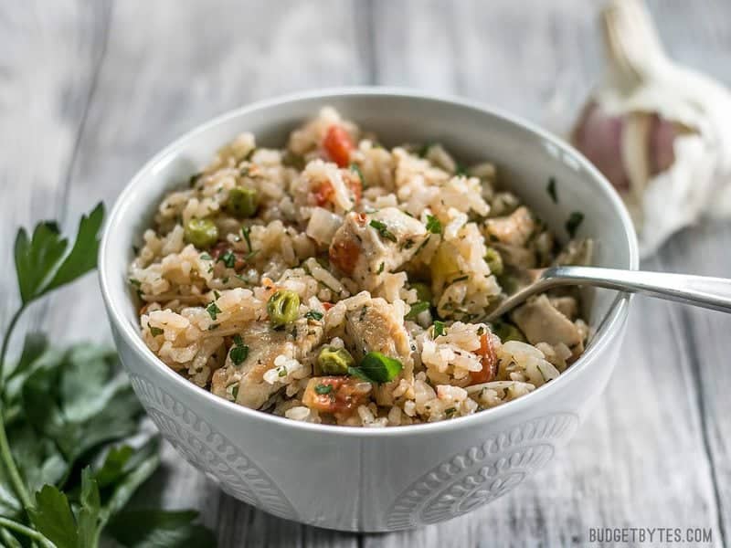 This Chimichurri Chicken and Rice is a bright and vibrant summer meal that cooks in just one pot to make dinner fast and easy. BudgetBytes.com Chimichurri Chicken and Rice in a bowl with a fork