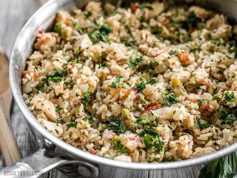 This Chimichurri Chicken and Rice is a bright and vibrant summer meal that cooks in just one pot to make dinner fast and easy. BudgetBytes.com Chimichurri Chicken and Rice in the skillet viewed from the side