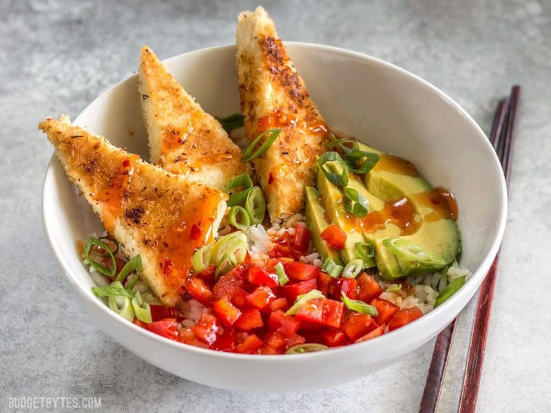 These subtly sweet Coconut Crusted Tofu dippers are the perfect vehicle for tangy sweet chili sauce. Serve as a snack or part of your favorite bowl meal. BudgetBytes.com Coconut Crusted Tofu bowl meal from the front