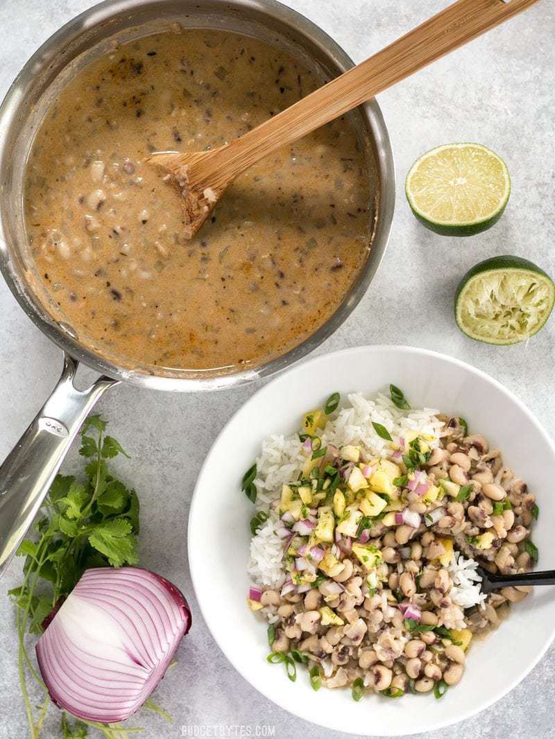 These rich and spicy Coconut Jerk Peas are super simple to make and pair brilliantly with a sweet and vibrant pineapple salsa. BudgetBytes.com A pot of Coconut Jerk Peas next to a bowl of peas with rice and salsa