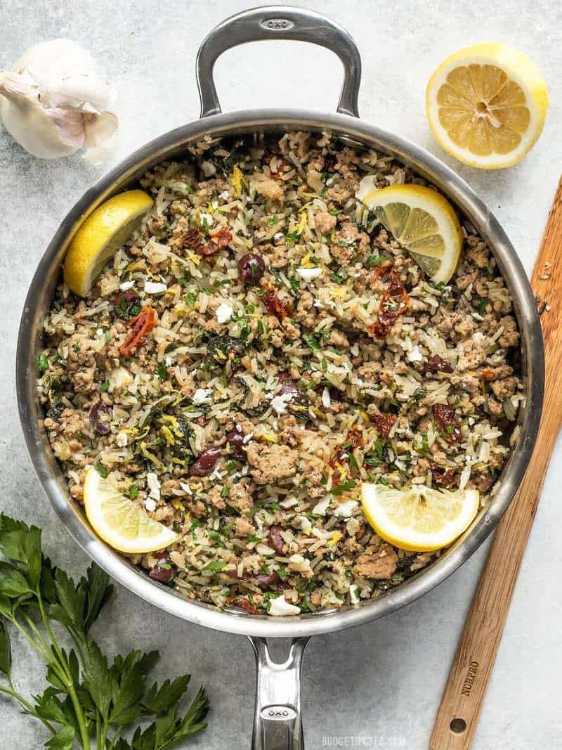 Greek Turkey and Rice Skillet is an easy and flavorful ground turkey recipe that cooks in one skillet for maximum flavor and minimum effort. Budgetbytes.com A large skillet full of Greek Turkey and Rice Skillet with lemon wedges, garlic, and parsley on the sides
