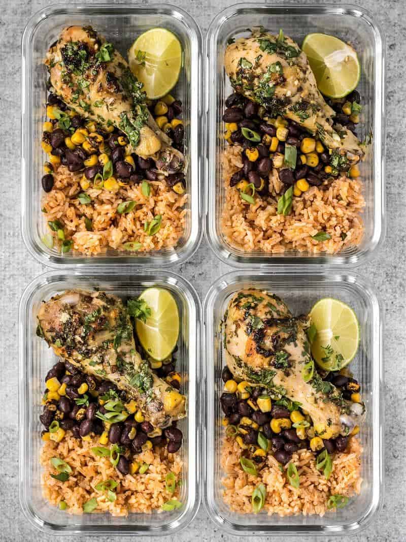 Bright and flavorful Cilantro Lime Chicken plus a classic Taco Rice and a smoky mix of corn and black beans makes an easy and hearty meal. BudgetBytes.com Four glass Cilantro Lime Chicken meal prep containers side by side