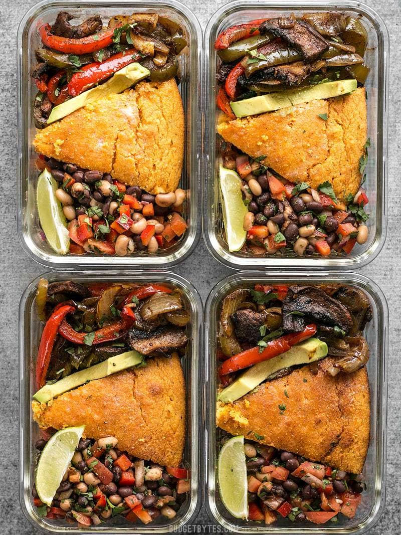 This smoky chipotle portobello fajita meal prep features mixed fajita vegetables, sweet potato cornbread, and cowboy caviar for a filling vegetarian meal! BudgetBytes.com Four glass smoky chipotle portobello fajita meal prep containers side by side