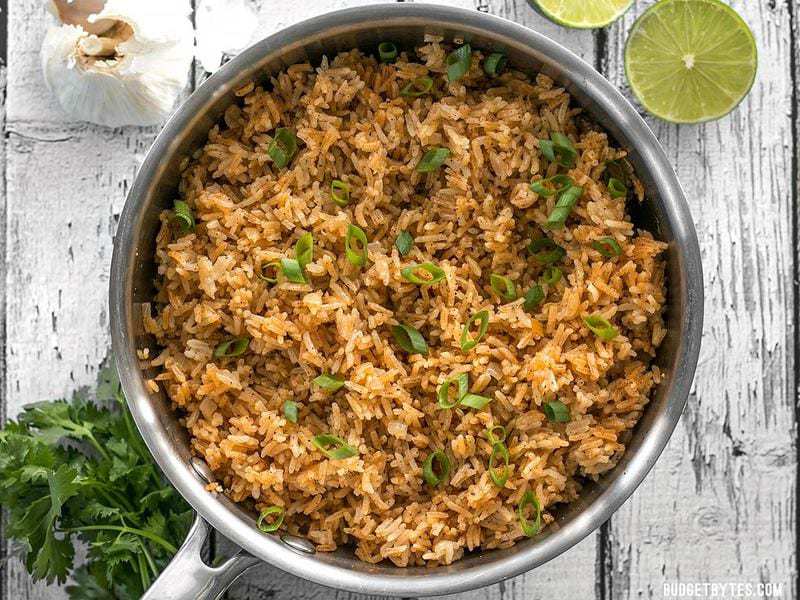 This flavorful Taco Rice is packed full of herbs and spices, but is neutral enough to serve as the base for several different recipes, like bowl meals, burritos, and more! BudgetBytes.com Overhead shot of the pot full of Taco Rice