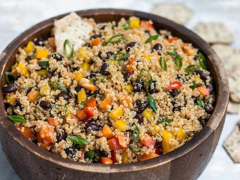 Enjoy this Smoky Quinoa and Black Bean Salad alone as a vegan meal, or as a side with grilled meat or fish. Full of flavor, color, texture and nutrients! Budgetbytes.com Front view of Smoky Quinoa and Black Bean Salad with a chip dipped in.