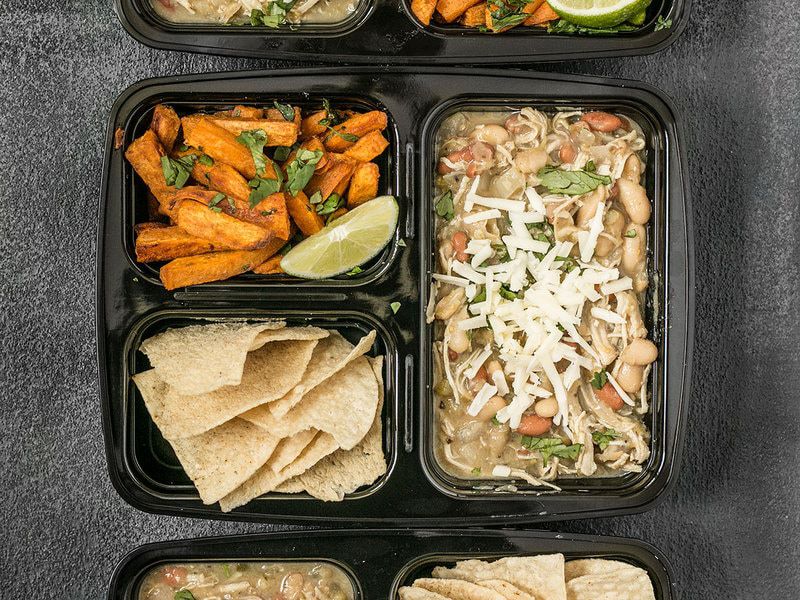 This White Chicken Chili Meal Prep includes a slow cooker chili with Cumin Lime Roasted Sweet Potatoes and tortilla chips for dipping! BudgetBytes.com Close up of one White Chicken Chili Meal Prep container