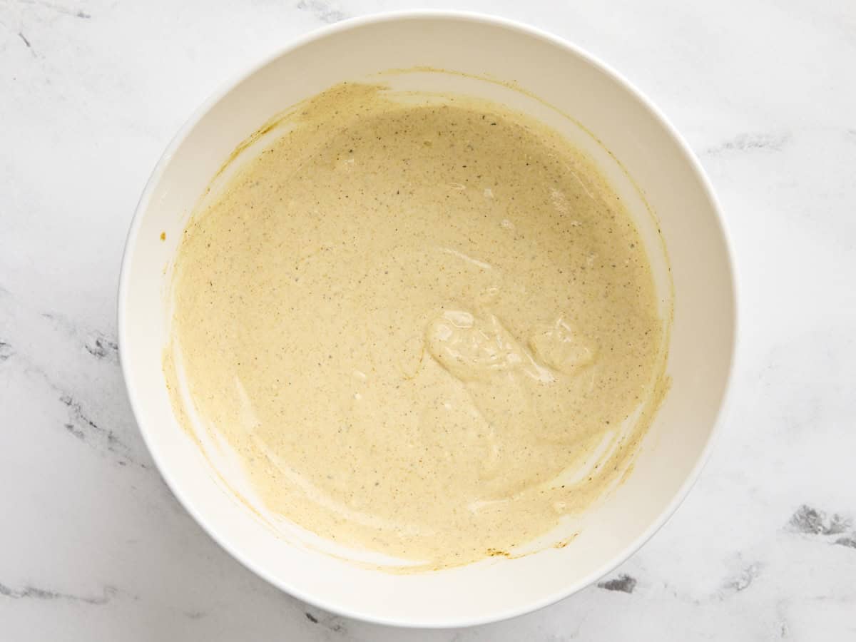 Curry chicken salad dressing in a mixing bowl.