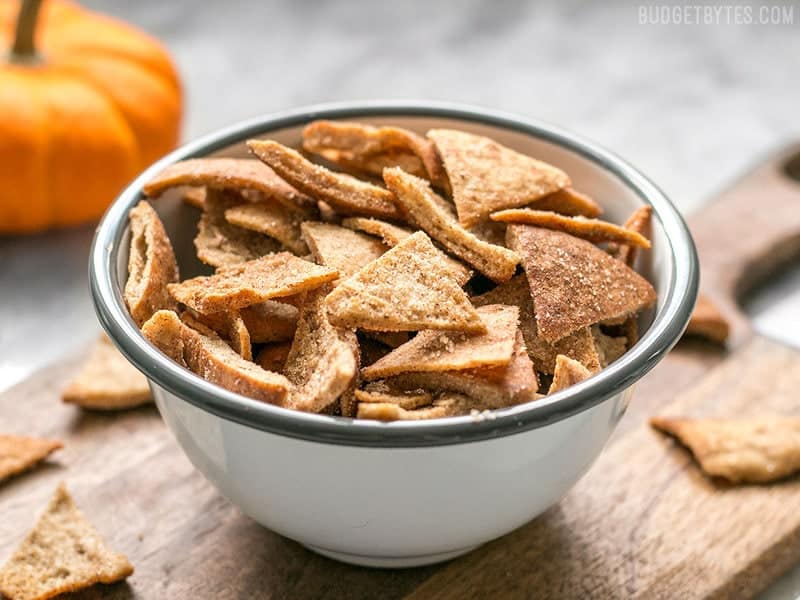 These Cinnamon Pita Crisps are a tasty little snack that's perfect for fall. Dip them into your favorite sweet treat or eat them on their own. BudgetBytes.com Front view of a bowl of Cinnamon Pita Crisps