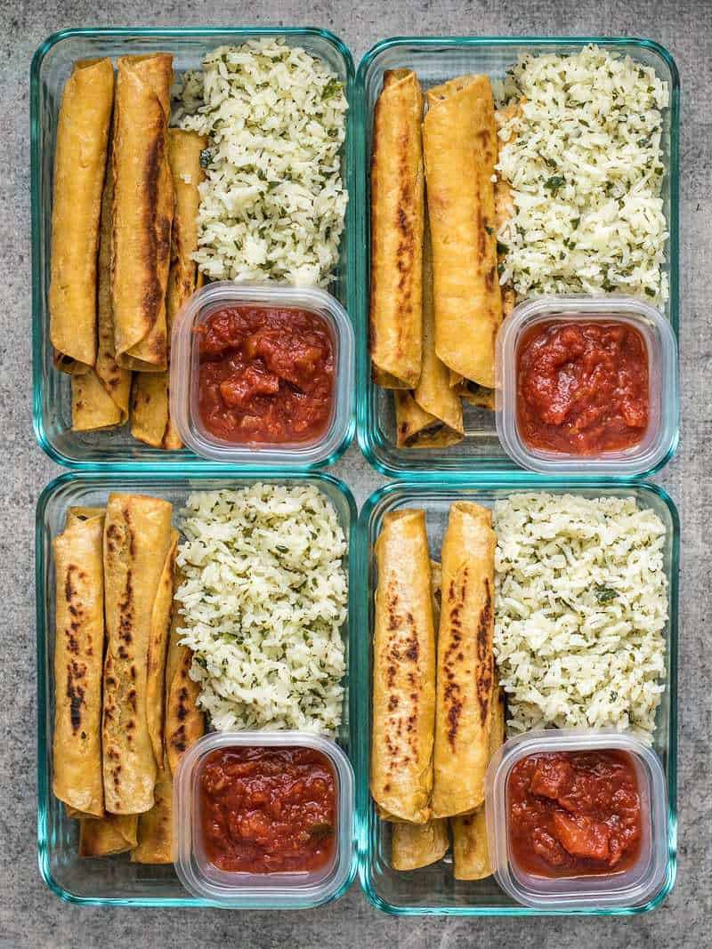 Creamy Black Bean Taquitos pair with tangy Cilantro Lime Rice for a simple and satisfying meal prep. BudgetBytes.com Four Creamy Black Bean Taquito meal prep containers with salsa and cilantro lime rice