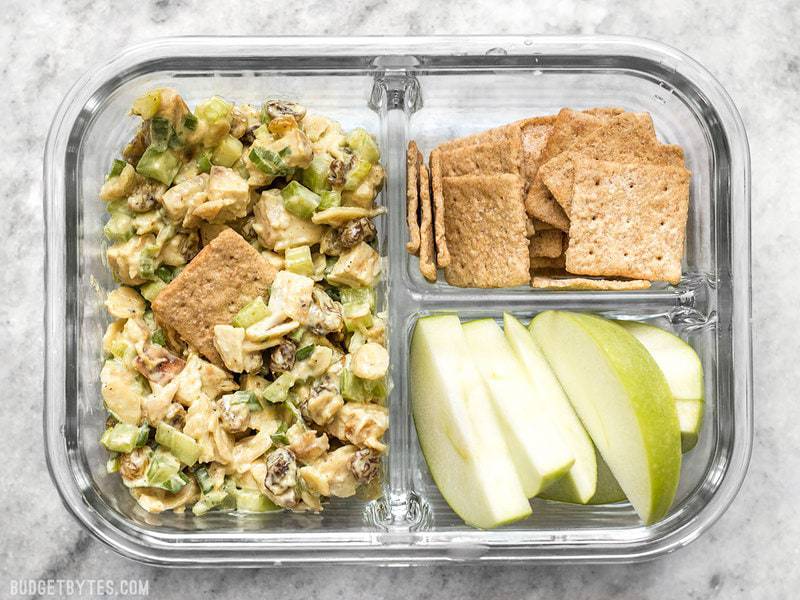 Curry Chicken Salad is paired with crunchy crackers for dipping and a tart apple to cleanse the palate in this simple cold lunch box. BudgetBytes.com A single Curry Chicken Salad meal prep container with crackers and apples