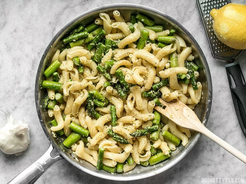 Lemon Garlic Asparagus Pasta is a fast, easy, and fresh weeknight dinner that you'll come back to again and again and have memorized in no time. BudgetBytes.com A skillet full of Lemon Garlic Asparagus Pasta with a wooden spoon and zested lemon on the side