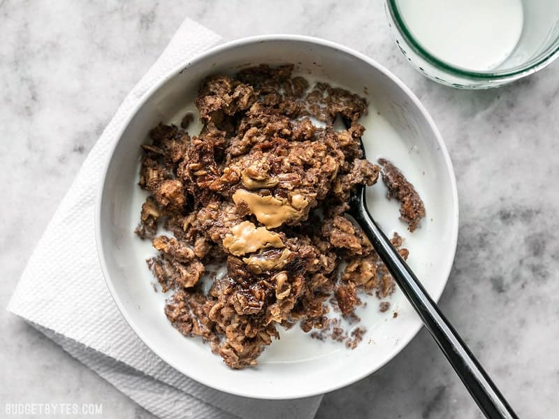 This Peanut Butter Brownie Baked Oatmeal is an indulgent-yet-healthy breakfast with rich chocolatey goodness and just a hint of sweetness. BudgetBytes.com A bowl of Peanut Butter Brownie Baked Oatmeal with milk poured over top